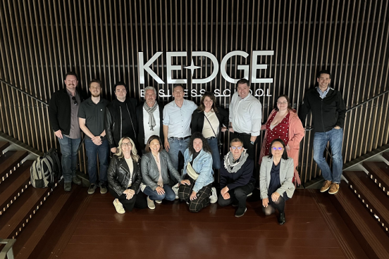 GWEMBA 4 students standing in front of Kedge Business School sign in Bordeaux, France.