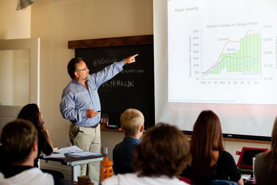 An instructor pointing to a slide in a classroom