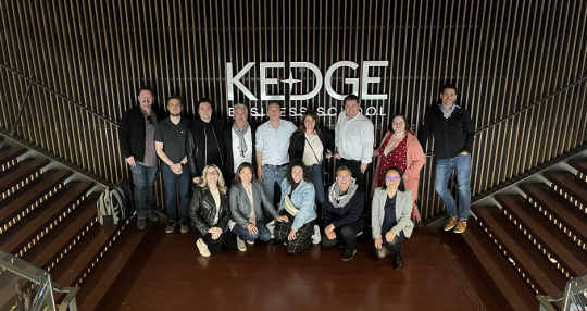 GWEMBA 4 students standing in front of Kedge Business School sign in Bordeaux, France.